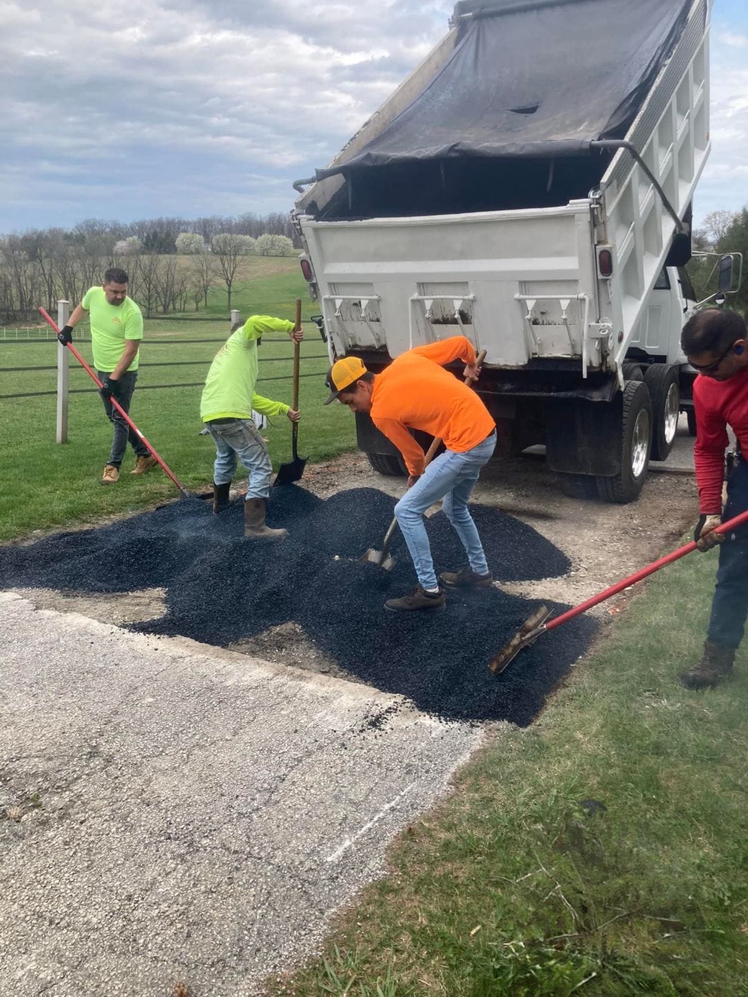 Workers paving a gravel surface.