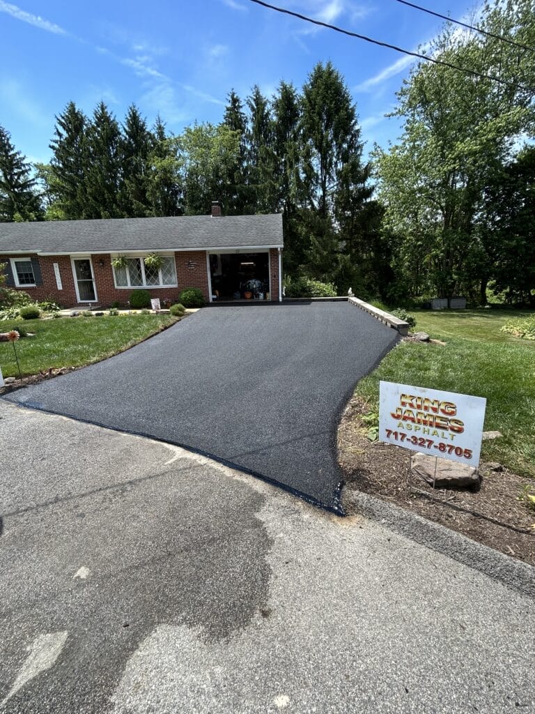 Freshly paved driveway next to house